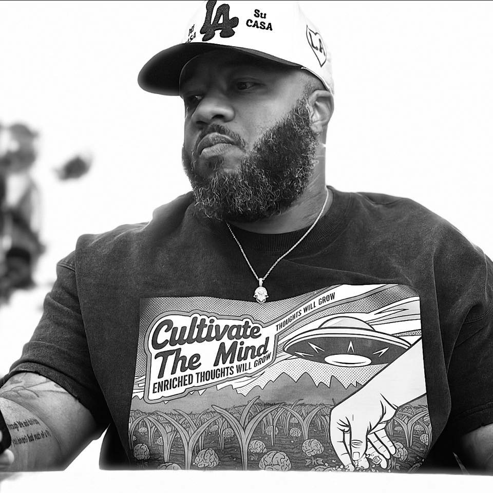 Bearded man wearing "Cultivate The Mind" shirt